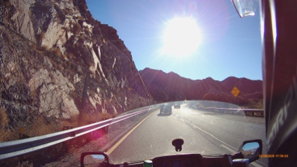 motorcycle pov on highway in mountains with sun
